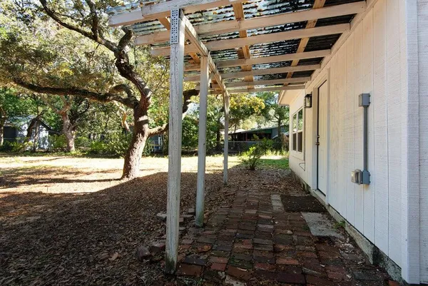 a view of a pathway of a house with yard and wooden fence