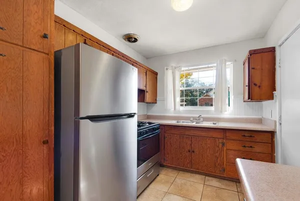 a kitchen with a sink a refrigerator and cabinets