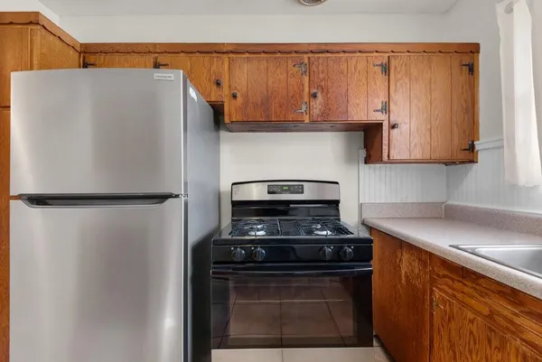 a kitchen with stainless steel appliances granite countertop a refrigerator and a stove