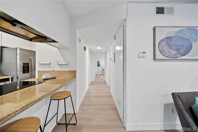 a view of a hallway with furniture and wooden floor