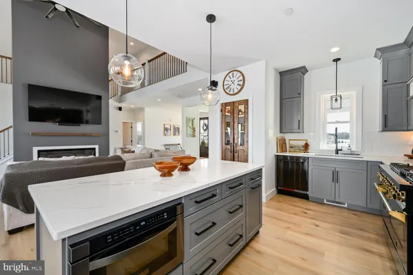 a living room with stainless steel appliances furniture a kitchen view and a kitchen view