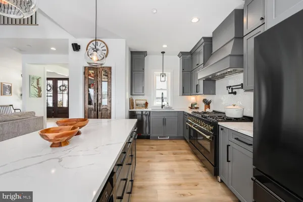 a view of living room kitchen with stainless steel appliances granite countertop furniture and a kitchen view