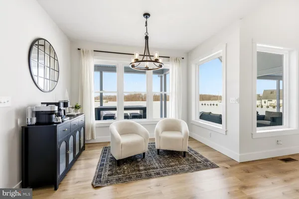 a kitchen with stainless steel appliances kitchen island granite countertop a refrigerator a stove a sink and a dining table with wooden floor