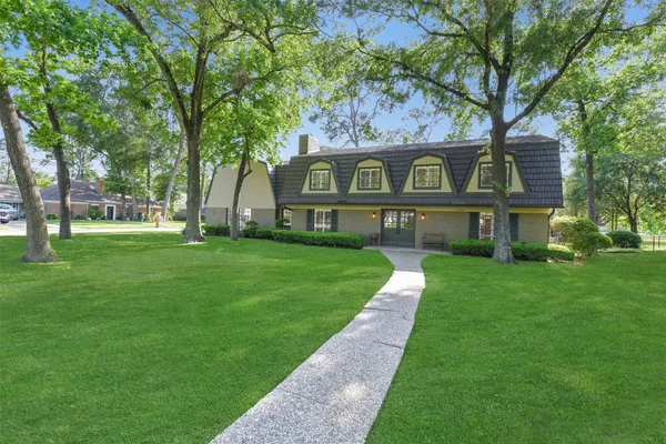 a front view of a house with a yard and trees
