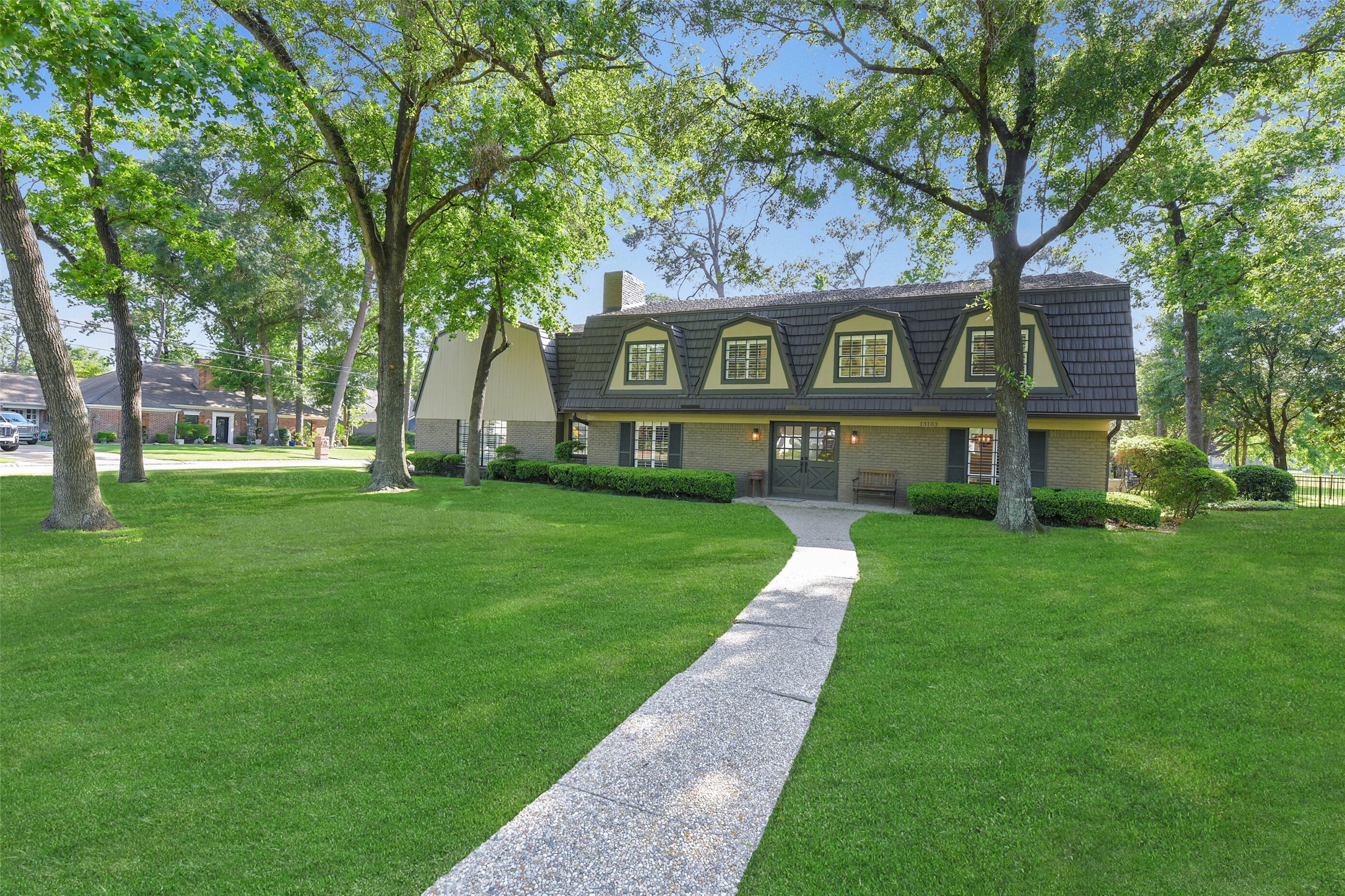 a front view of a house with a yard and trees
