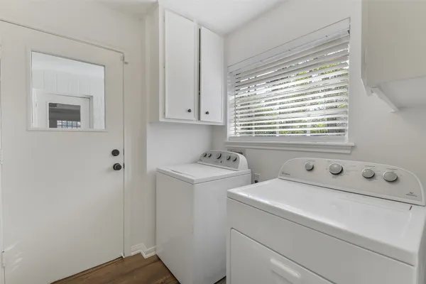 a view of washer and dryer with bathroom in the background