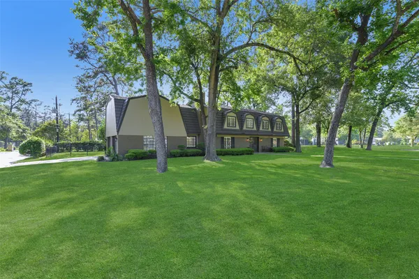 a view of a house with backyard and trees