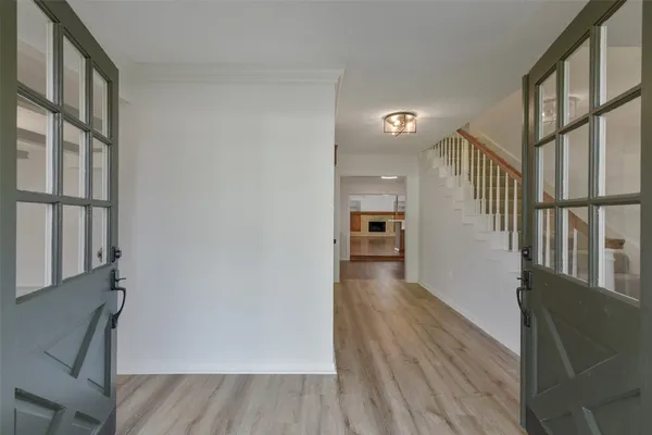 a view of a hallway with wooden floor and staircase