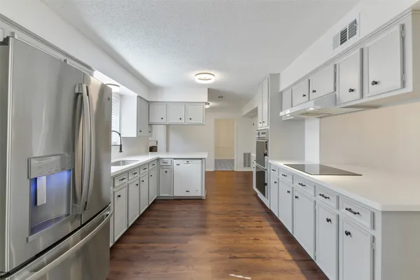 a kitchen with granite countertop lots of counter top space and stainless steel appliances