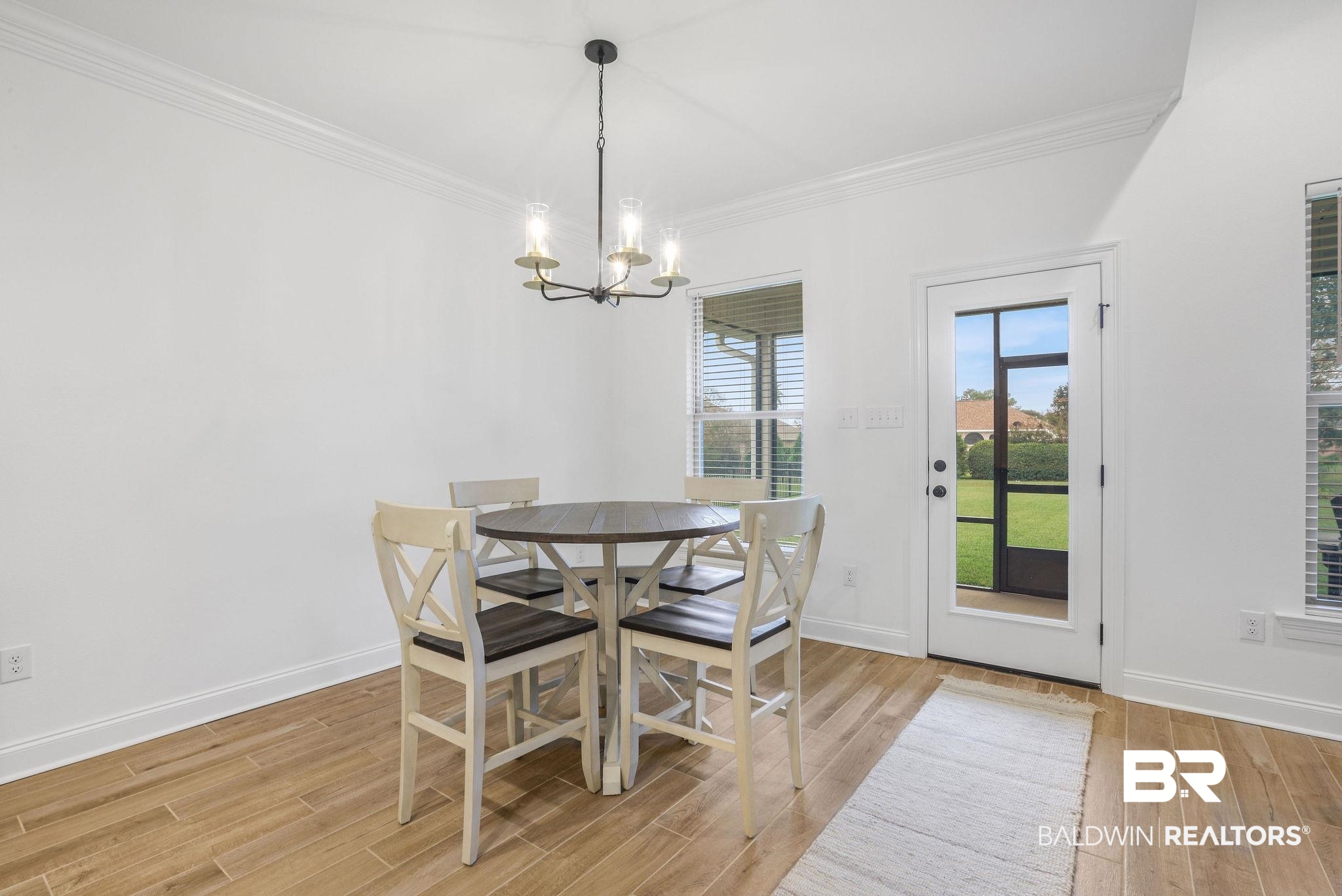 9855 Chipper Lane Foley, AL 36535 - Photo 31 of 48 Dining area featuring a chandelier, light hardwood / wood-style floors, and ornamental molding