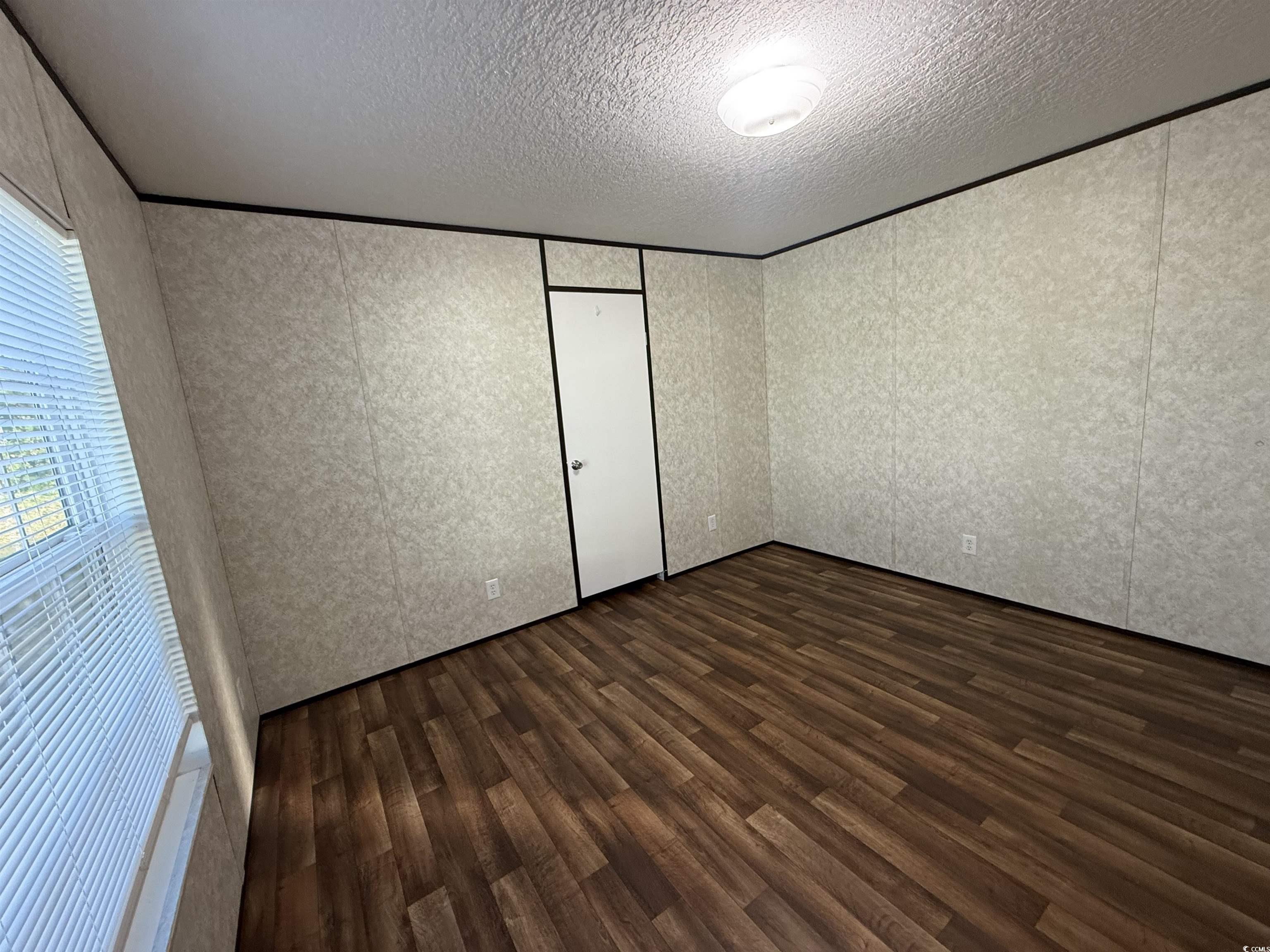 131 Shetland Woods Drive Myrtle Beach, SC 29577 - Photo 15 of 20 Unfurnished bedroom with dark wood-style floors, a closet, and a textured ceiling