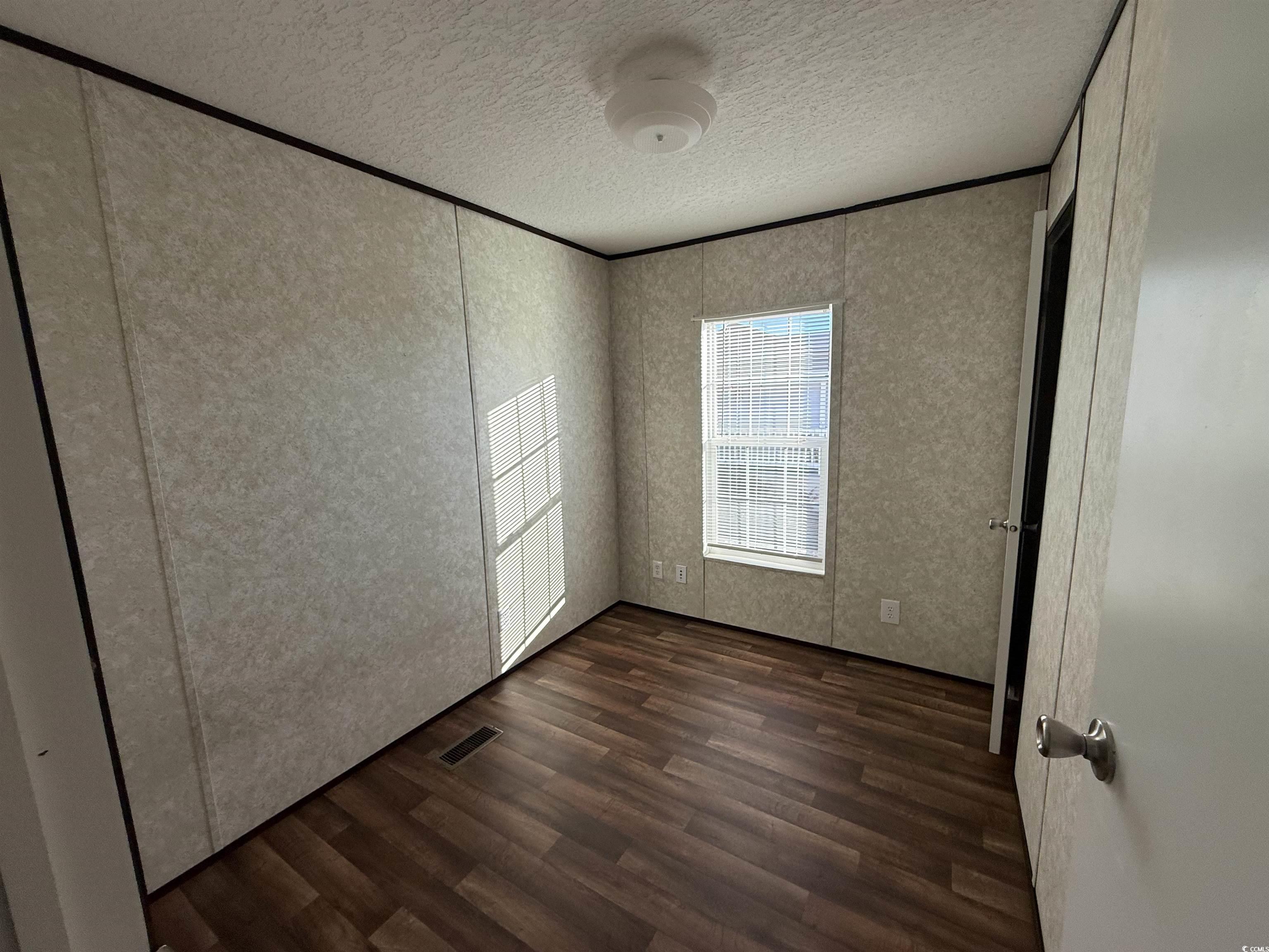131 Shetland Woods Drive Myrtle Beach, SC 29577 - Photo 16 of 20 Unfurnished bedroom with dark wood-type flooring and a textured ceiling