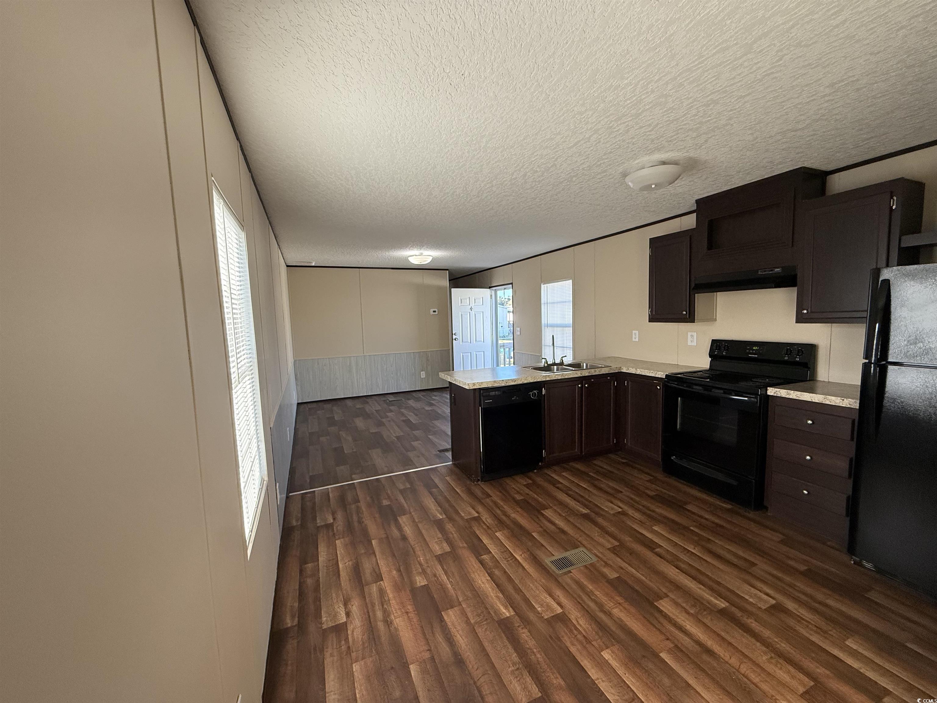 131 Shetland Woods Drive Myrtle Beach, SC 29577 - Photo 20 of 20 Kitchen with light countertops, a peninsula, open floor plan, black appliances, and a textured ceiling
