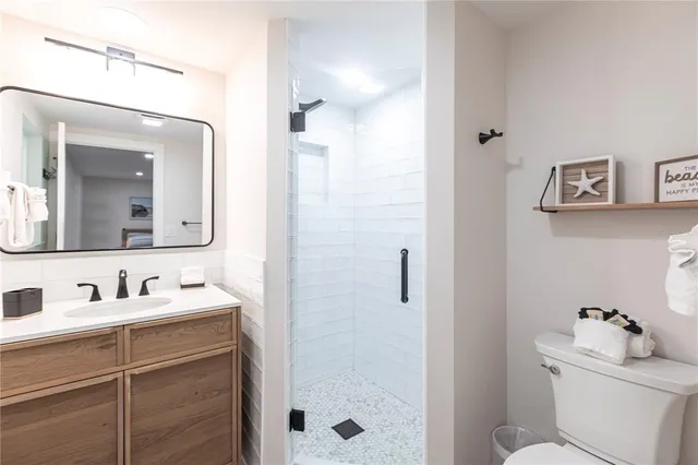 a bathroom with a sink a toilet and shower