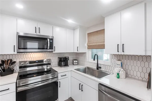 a kitchen with a sink stove and microwave
