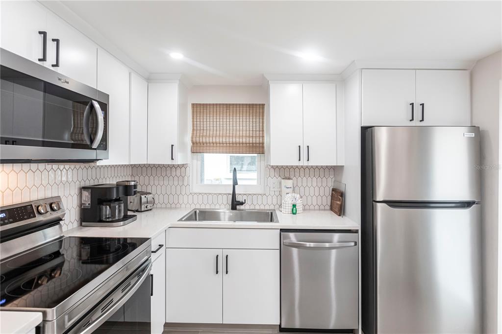 6154 Midnight Pass Road, Unit B18 Sarasota, FL 34242 - Photo 9 of 20 a kitchen with a refrigerator stove and microwave