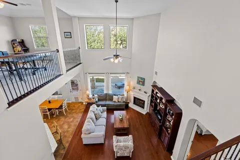 a view of a livingroom with furniture hardwood floor and windows
