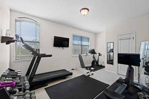 a room with gym equipment and a flat screen tv