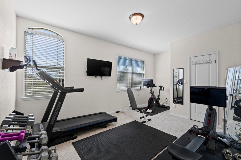 15104 Spillman Ranch Loop Austin, TX 78738 - Photo 19 of 31 a room with gym equipment and a flat screen tv