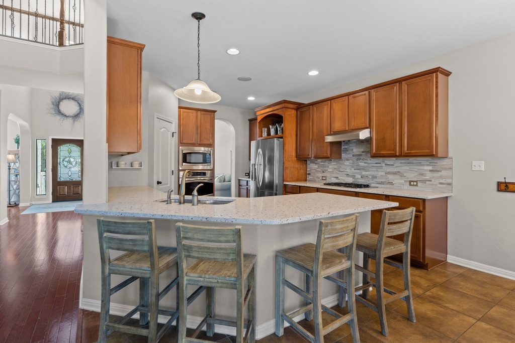 15104 Spillman Ranch Loop Austin, TX 78738 - Photo 6 of 31 a kitchen with a table chairs refrigerator and microwave
