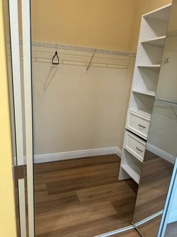 a view of walk in closet with empty racks