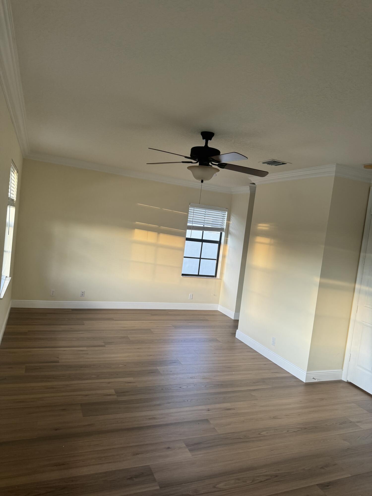 168 Astor Circle Delray Beach, FL 33484 - Photo 18 of 18 a view of empty room with wooden floor and fan