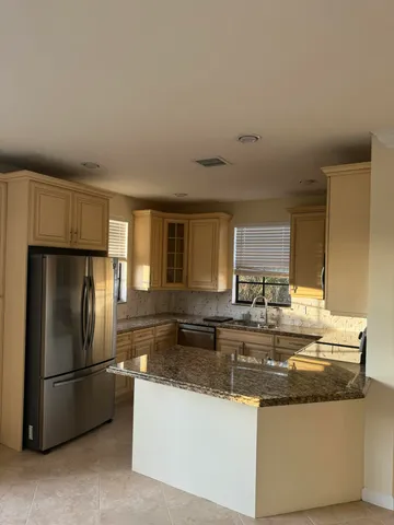 a kitchen with stainless steel appliances granite countertop a lot of counter top space and refrigerator