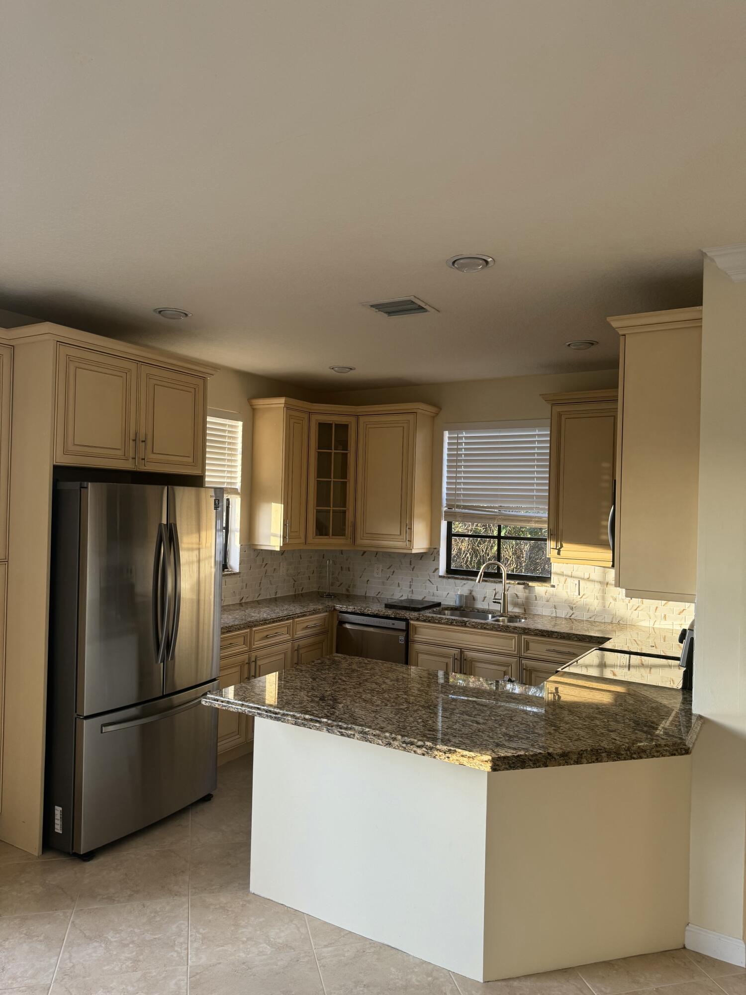 168 Astor Circle Delray Beach, FL 33484 - Photo 4 of 18 a kitchen with stainless steel appliances granite countertop a lot of counter top space and refrigerator