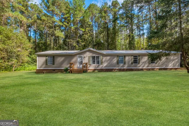 a view of a house with a yard table and chairs