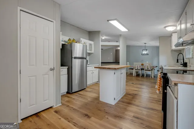 a kitchen with stainless steel appliances a refrigerator and a stove top oven