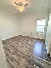 a view of a hallway with wooden floor and a cabinet