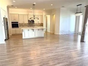 a kitchen with stainless steel appliances granite countertop a refrigerator a stove and a wooden floors