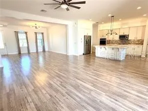 a view of a kitchen with kitchen island and stainless steel appliances