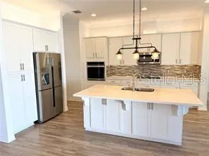 a kitchen with stainless steel appliances granite countertop a sink a refrigerator and a stove
