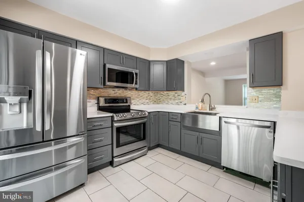 a kitchen with granite countertop a refrigerator stove and microwave