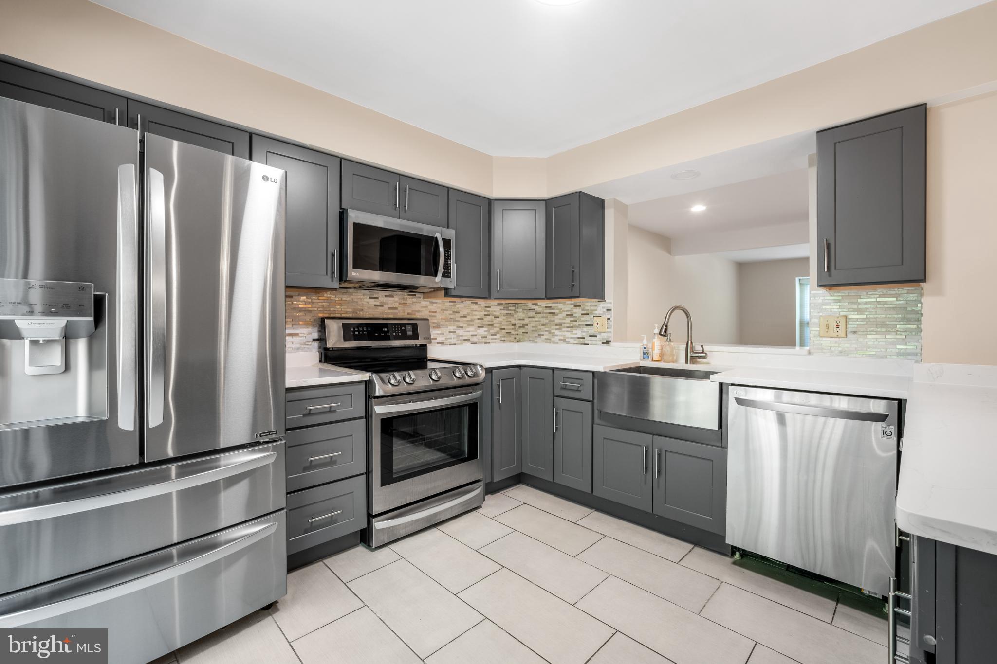 11521 Shell Flower Lane Columbia, MD 21044 - Photo 11 of 31 a kitchen with granite countertop a refrigerator stove and microwave