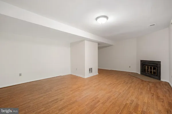a view of an empty room with a fireplace and a window