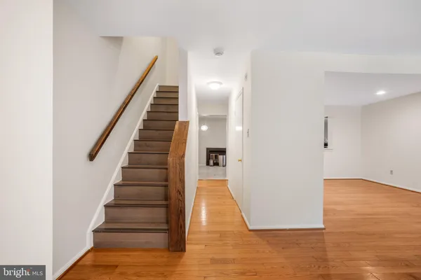 a view of a hallway with wooden floor and staircase