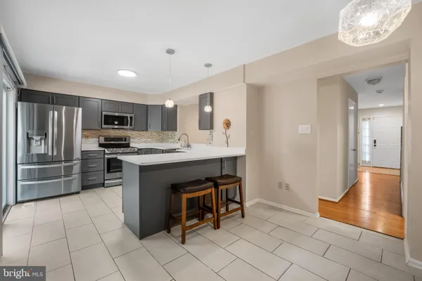 a kitchen with stainless steel appliances granite countertop a refrigerator and a stove top oven