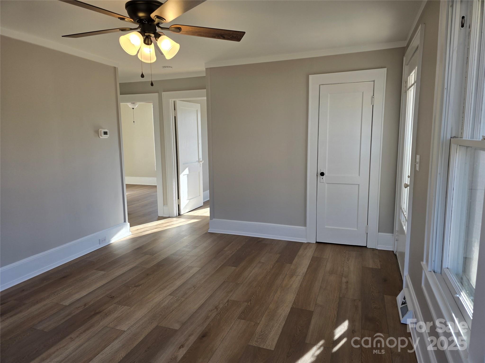 36040 Palestine Road Albemarle, NC 28001 - Photo 6 of 43 an empty room with wooden floor fan and windows