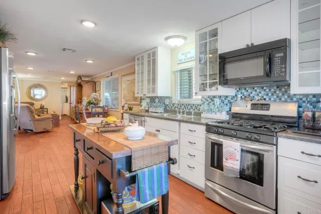 a kitchen with stainless steel appliances granite countertop a stove and a sink
