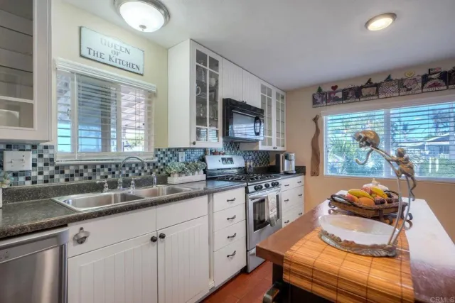 a kitchen with stainless steel appliances granite countertop a sink stove and cabinets