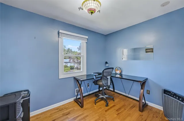 a view of a workspace with furniture and a window
