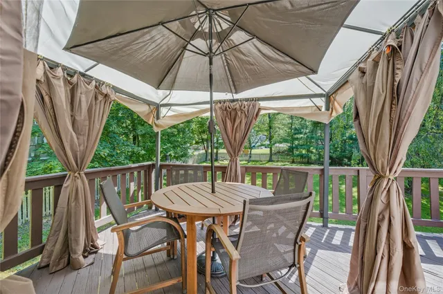 a view of patio with table and chairs under an umbrella