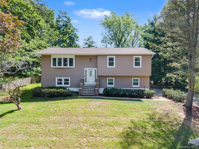 a front view of a house with a yard and trees