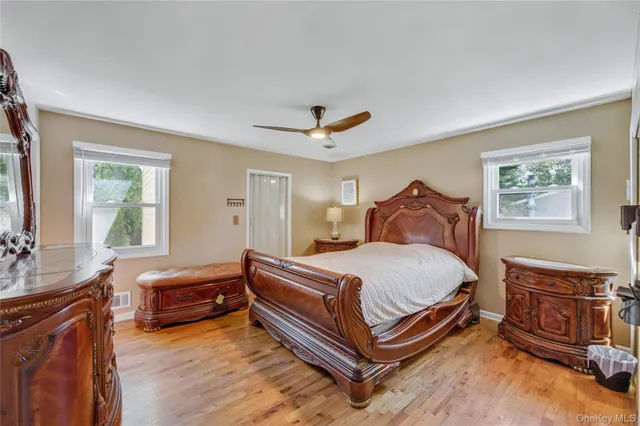 a bedroom with a bed and a dresser next to a window