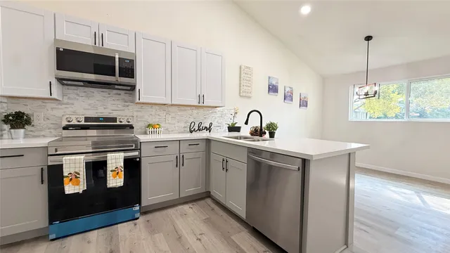 a kitchen with stainless steel appliances a stove a sink a microwave and cabinets