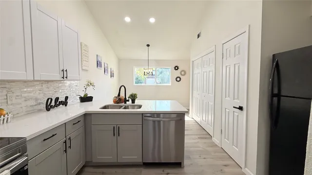 a kitchen with a sink a refrigerator and cabinets