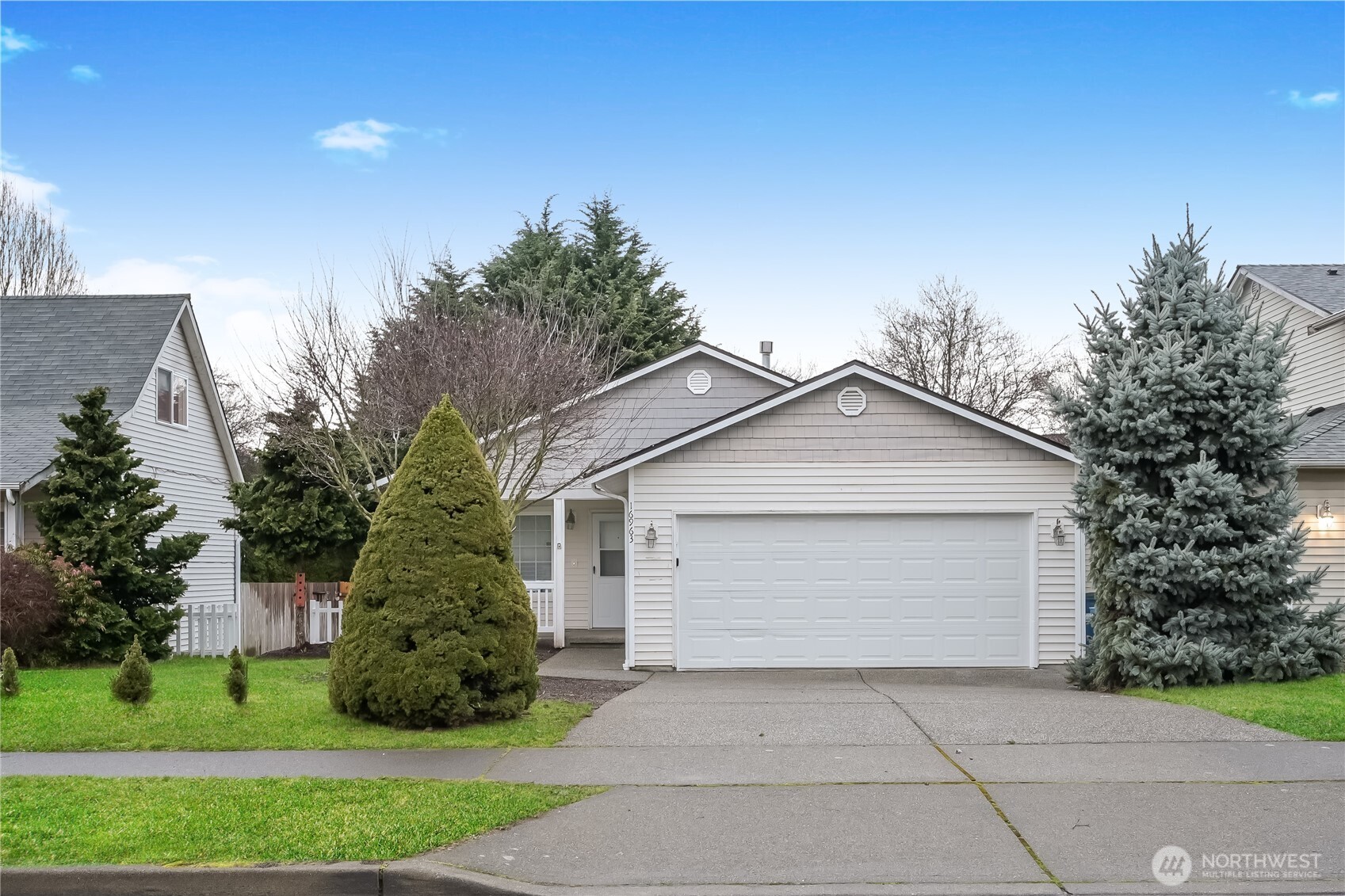 a front view of a house with a yard and trees