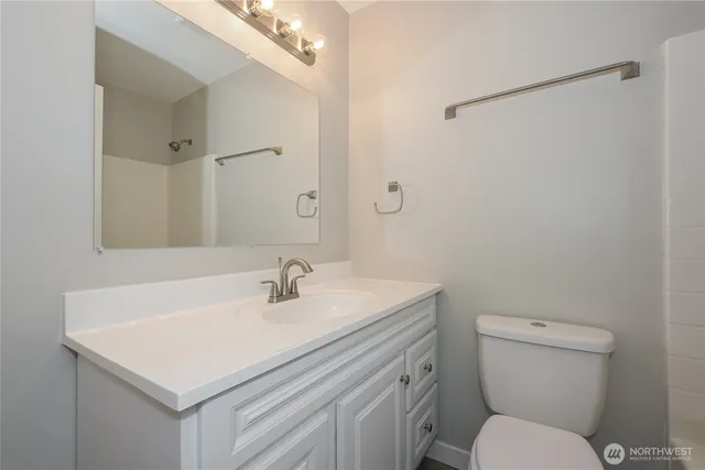 a bathroom with a sink toilet vanity and shower